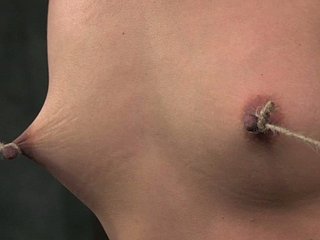 Zrujnowana brunetka dokuje jej sutki przywiązane do stóp pod presją